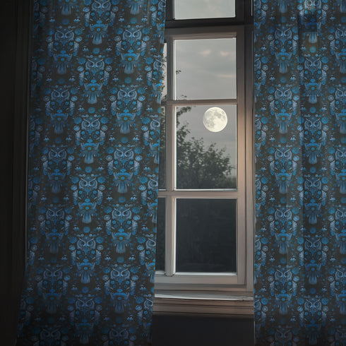 A sheer curtain panel featuring a repeating pattern of stylized owls in luminous blue tones, surrounded by delicate botanical flowers and flourishes on a dark background.